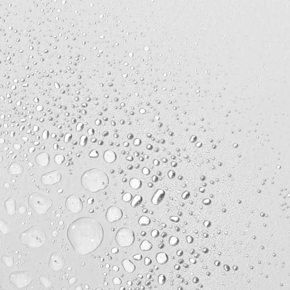 dermalogica multi-active toner droplets on a glass surface with a light gray background