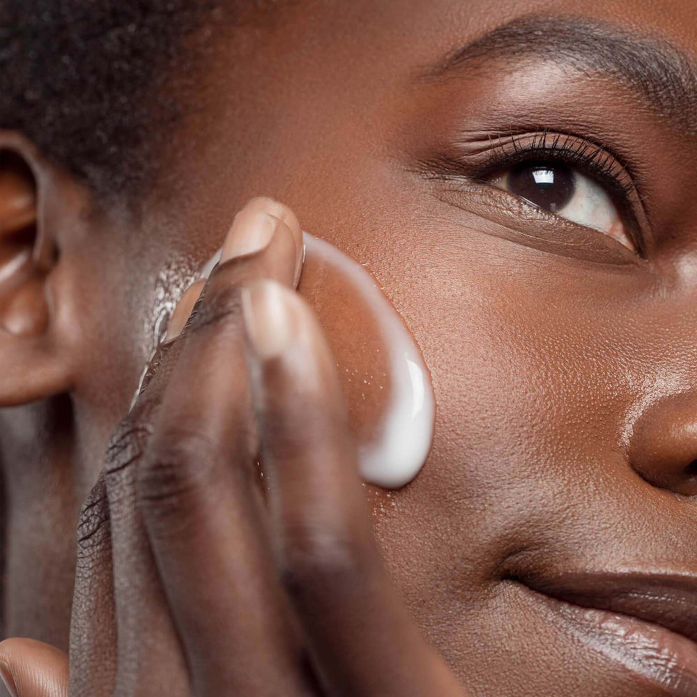 Person applying dermalogica smart response serum to their face with a close-up focus on the action.